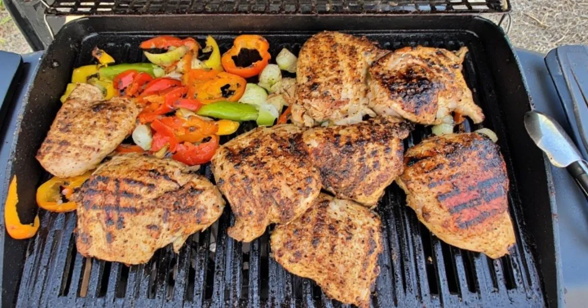 Juicy grilled chicken breast sizzling on a Blackstone griddle outdoors
