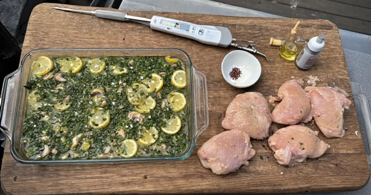 Essential tools for griddle cooking including spatula, tongs, oil bottle, and meat thermometer next to a Blackstone griddle. 
