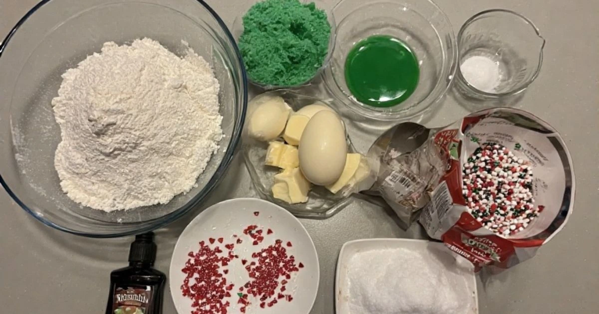 Essential ingredients for the festive Grinch cookies recipe, including green food coloring and heart sprinkles.
